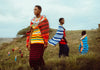 A group of Maasai women in Tanzania, 2021, dressed in vibrant traditional clothing, standing gracefully against the calm backdrop of nature.