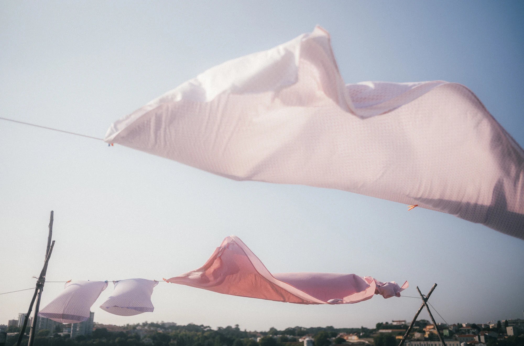 Delicate fabrics glowing in cinematic colors, gently swaying in the wind in Porto, Portugal, 2024.